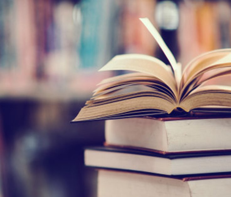 An open book on a stack of books